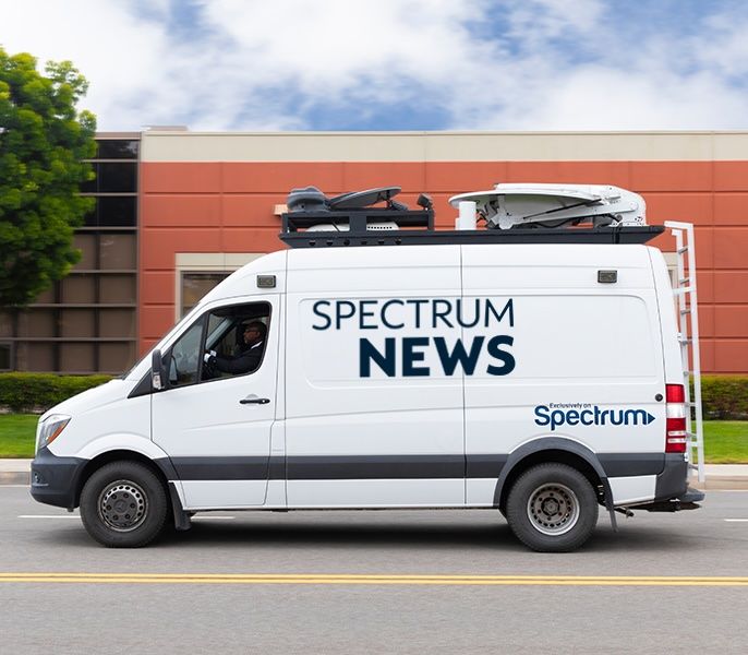 Spectrum News van with logo on the side of it