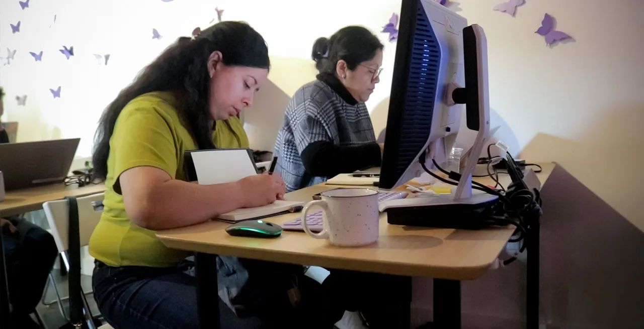 Two adult students using computers in a computer lab