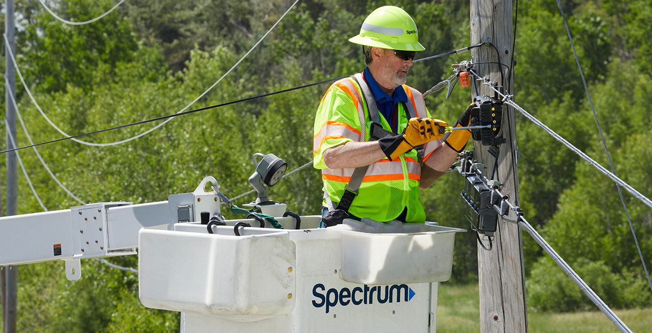 Spectrum technician working in a bucket on a broadband expansion project